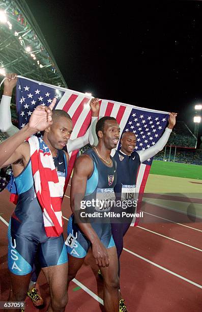 Michael Johnson of the USA walks to greet fans with his teammates after winning the Gold Medal in the Mens 4x400m Final Event during the 2000 Sydney...