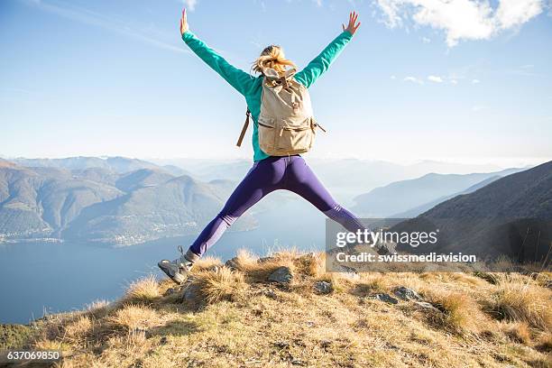 la mujer excursionista celebra el éxito en la cima de la montaña - letra x fotografías e imágenes de stock