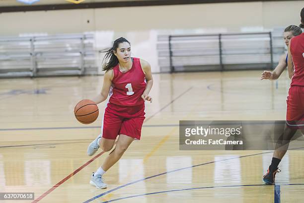 female high school basketball player dribbling to hoop - female basketball player stockfoto's en -beelden