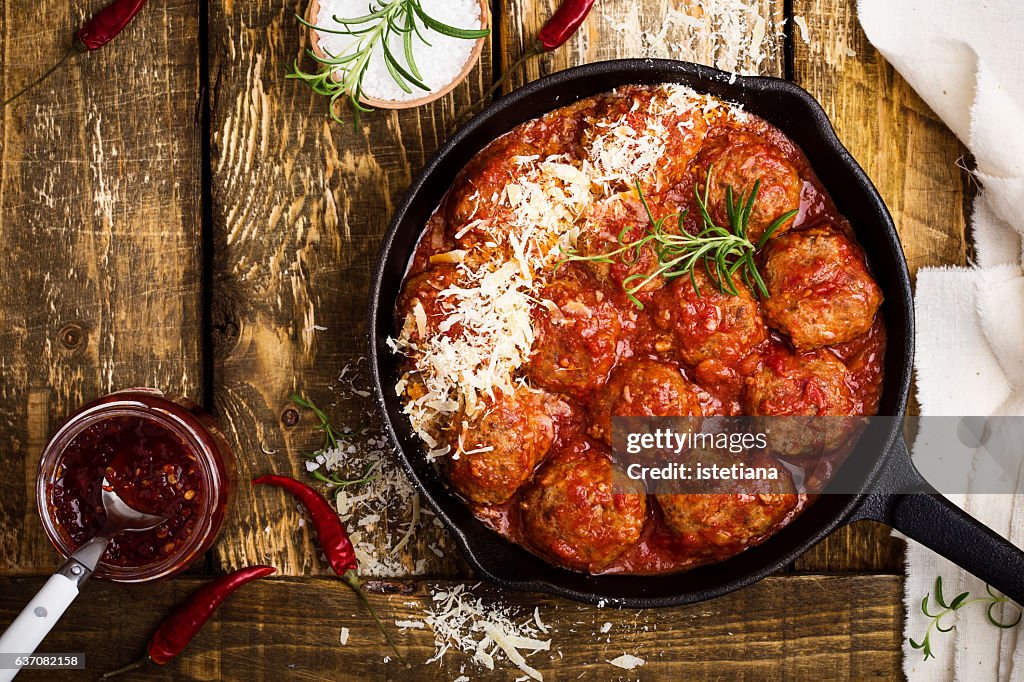 Meatballs in sour tomato sauce with grated parmesan cheese on top