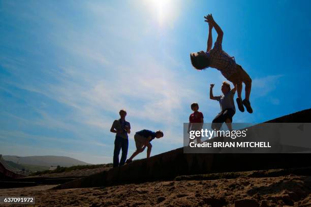 young boys leaping and jumping in the air - isle of man stock pictures, royalty-free photos & images