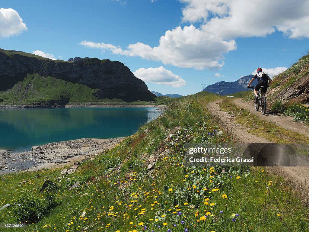 Biker On Mountain Road On The Shores Of Lake Toggia, Formazza Valley, Northern Italy