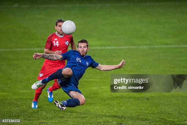 football players playing football - two guys playing soccer stockfoto's en -beelden