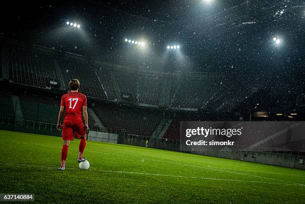 jugador de fútbol de pie en el estadio - reflector objeto fabricado fotografías e imágenes de stock
