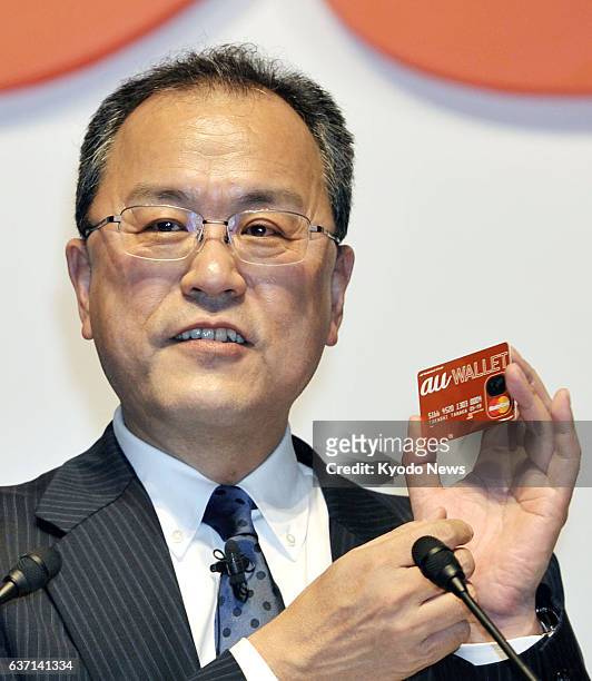 Japan - KDDI Corp. President Takashi Tanaka shows an "au Wallet" card for its new prepaid card program in Tokyo on May 8, 2014. This service will be...