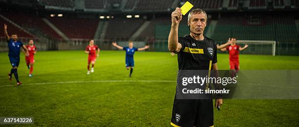 referee holds up yellow card - fluit sportartikelen stockfoto's en -beelden