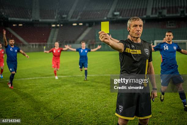 l'arbitro regge il cartellino giallo - ammonite foto e immagini stock