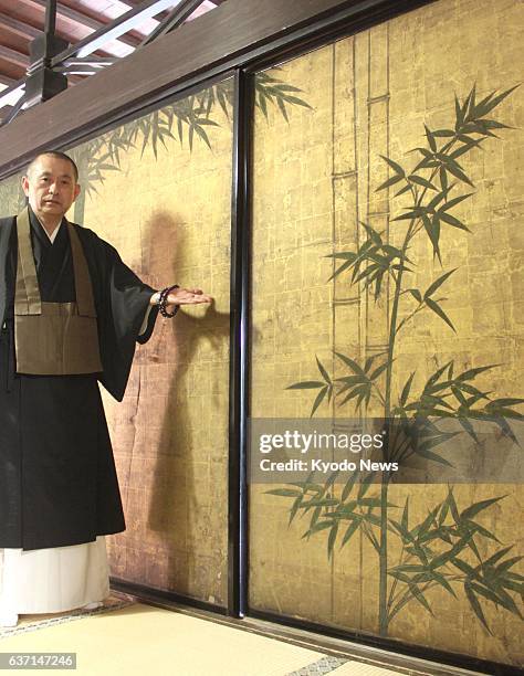 Japan - A Buddhist monk at Ryoshoin temple in Kyoto, western Japan, shows a painting on sliding doors reputedly drawn by 16th-17th century painter...