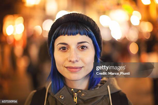 young woman bluehair walking through citylight - portrait awe stock pictures, royalty-free photos & images