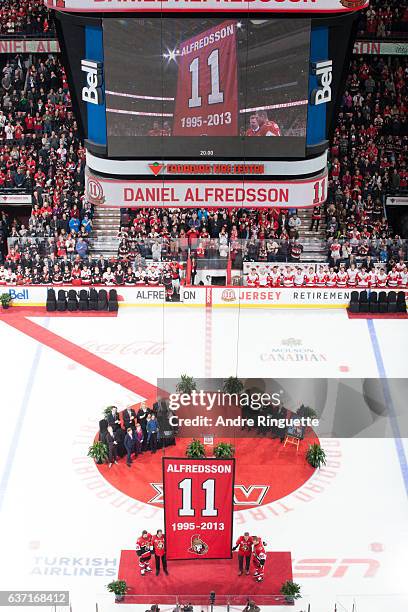 Daniel Alfredsson of the Ottawa Senators stands with former teammates Erik Karlsson, Chris Phillips and Chris Neil with his banner during a jersey...