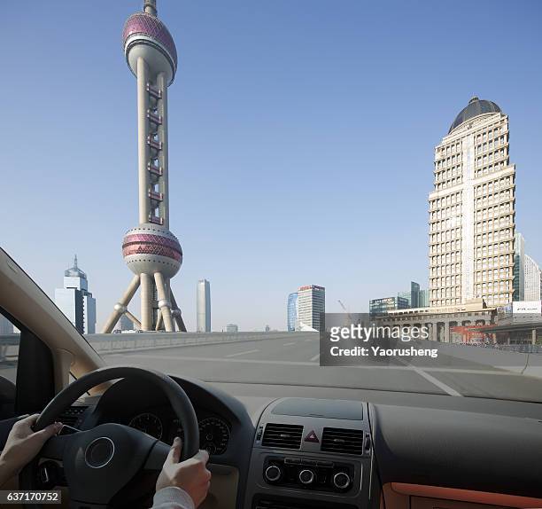 driving a car to a modem city,shanghai - auto cockpit stock pictures, royalty-free photos & images