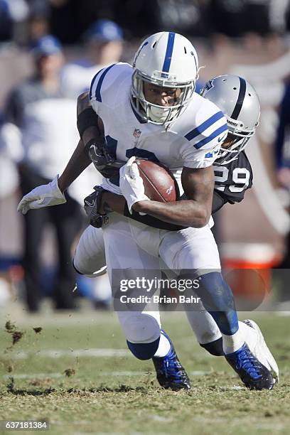 Wide receiver T.Y. Hilton of the Indianapolis Colts picks up 12 yards against cornerback David Amerson of the Oakland Raiders in the second quarter...