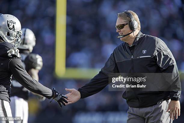 Head coach Jack Del Rio of the Oakland Raiders congratulates safety Reggie Nelson on an interception for a touchback against the Indianapolis Colts...