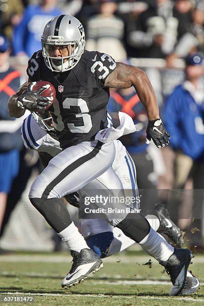 Running back DeAndre Washington of the Oakland Raiders runs for his second 22-yard touchdown against cornerback Vontae Davis of the Indianapolis...