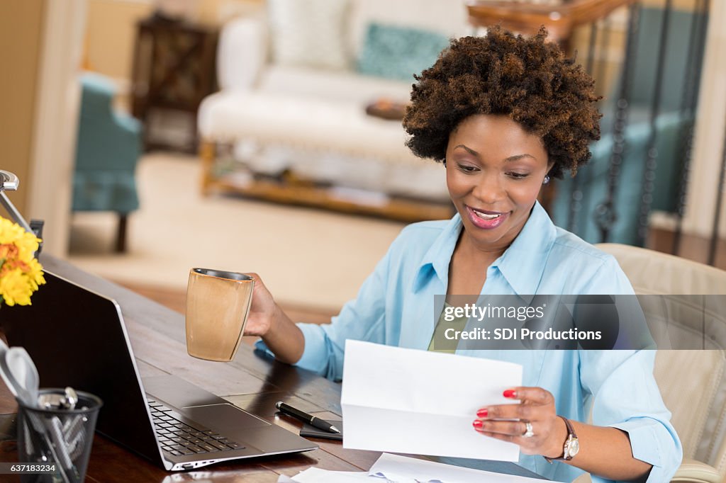 Self employed woman reads her mail in home office