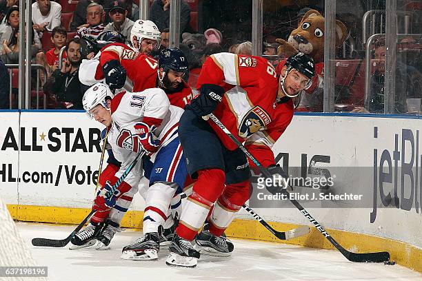 Jakub Kindl of the Florida Panthers digs the puck out from the boards against Brendan Gallagher of the Montreal Canadiens at the BB&T Center on...