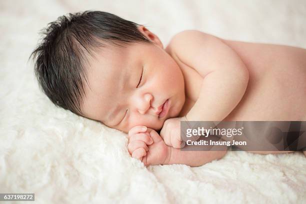 newborn baby sleeping in bed - korean baby girl stock-fotos und bilder