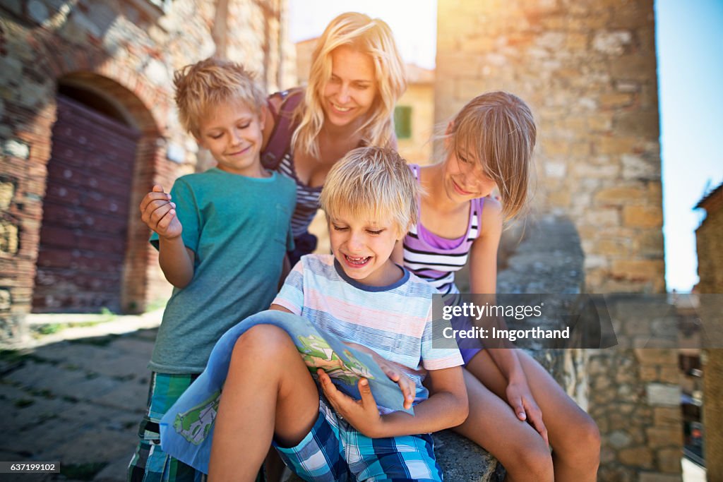 Mother and children tourist checking map in an Italian town