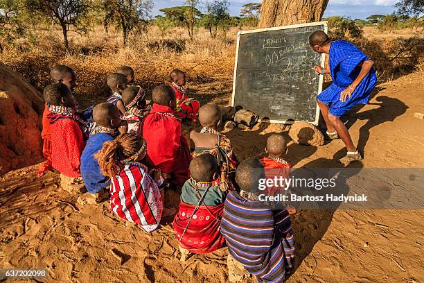 afrikanische kinder in der schule unter baum, kenia, ostafrika - african village stock-fotos und bilder