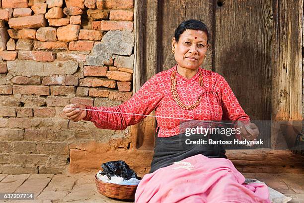 nepali woman spinning the wool - nepal culture stock pictures, royalty-free photos & images