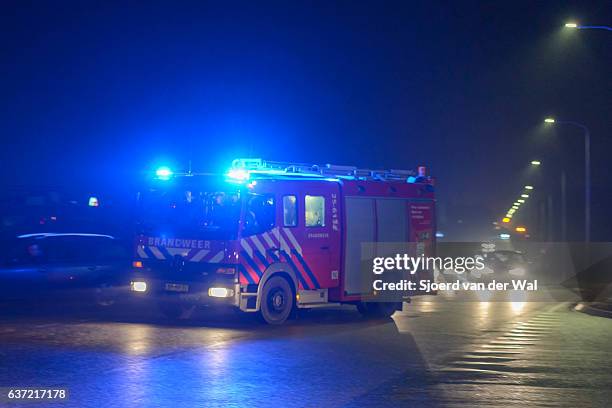fire engine rushing towards a fire at night - doven stockfoto's en -beelden