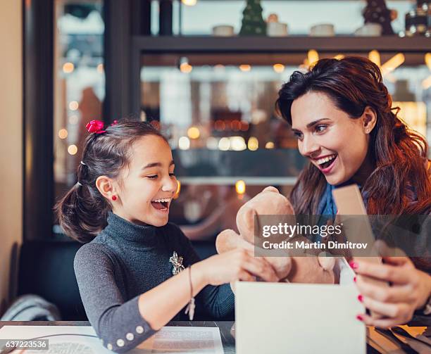 kleines mädchen genießt ein geburtstagsgeschenk - child giving gift stock-fotos und bilder