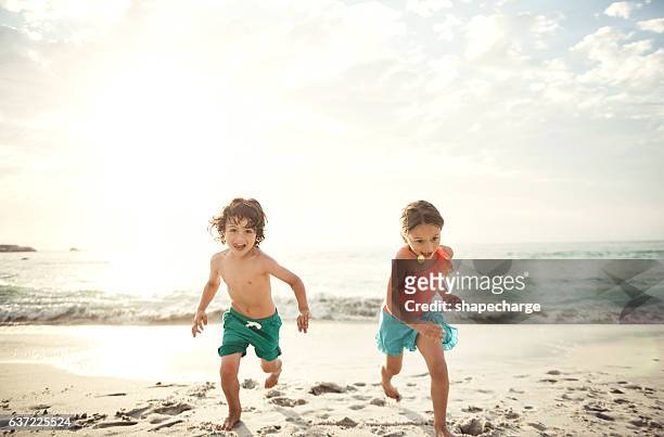 砂の向こう側でお互いを競う - swimwear ストックフォトと画像