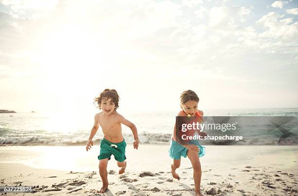 racing each other across the sand - badkläder bildbanksfoton och bilder