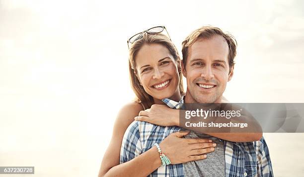 abrazándose bajo el sol - pareja de mediana edad fotografías e imágenes de stock