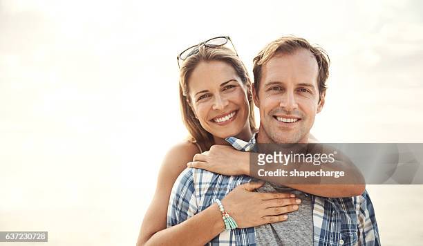 embracing each other under the sun - mid adult couple stock pictures, royalty-free photos & images