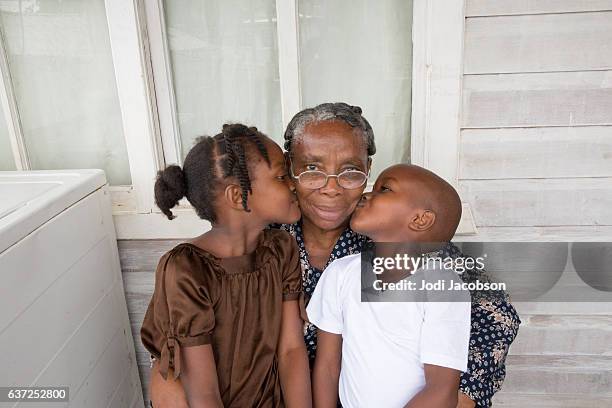 serie:orgullosa abuela hondureña recibiendo besos de nietos - caribbean culture fotografías e imágenes de stock