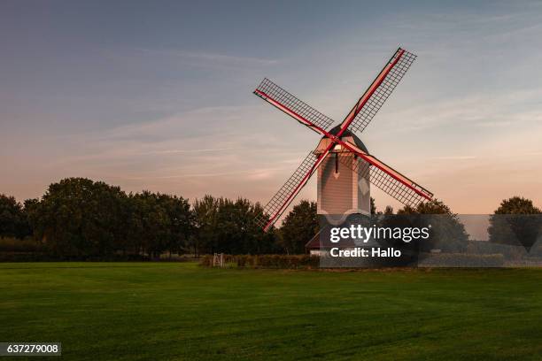 a historic windmill at sunset with a bench - house golden hour stock pictures, royalty-free photos & images