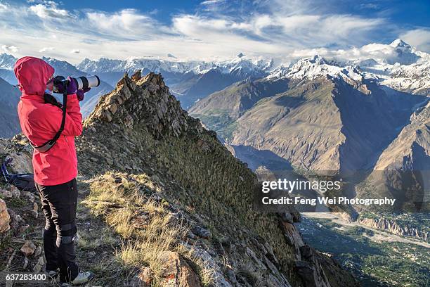 female tourist taking photos on hon pass, ultar trek, karimabad, hunza valley, gilgit-baltistan, pakistan - hunza valley stock-fotos und bilder