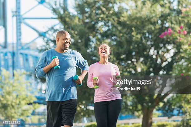 公園で一緒に走る黒人カップル、笑う - african american couple walking park ストックフォトと画像