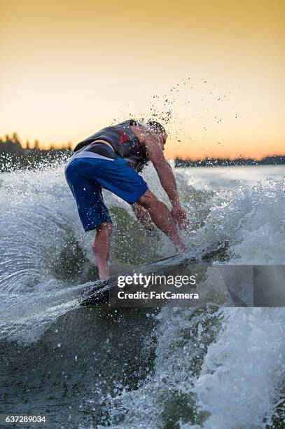 adult male wakesurfing at sunset on giant wake - giant camera stock pictures, royalty-free photos & images