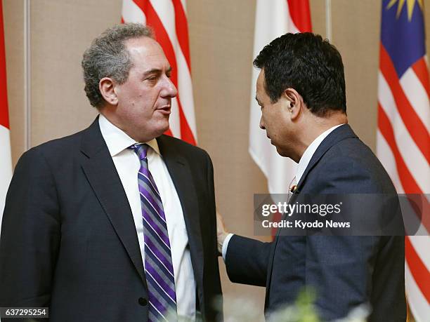 Singapore - U.S. Trade Representative Michael Froman and Akira Amari, Japan's minister in charge of Trans-Pacific Partnership negotiations, converse...