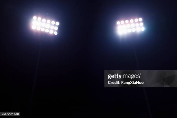 view of stadium lights at night - spotlicht stockfoto's en -beelden