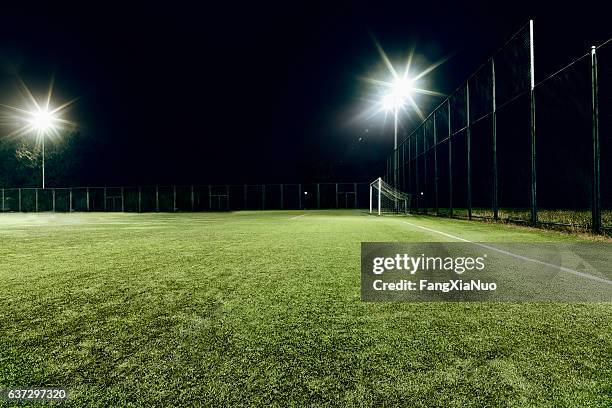 view of soccer field illuminated at night - turf stock pictures, royalty-free photos & images