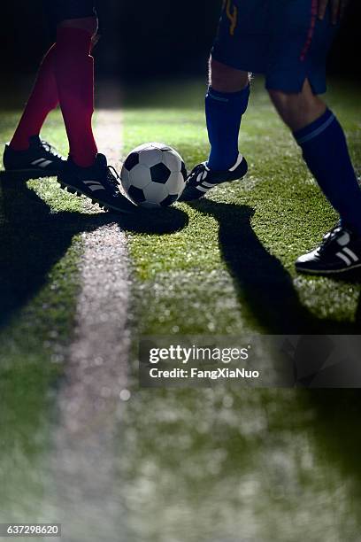 atleta driblando pelota de fútbol en el campo - driblar deportes fotografías e imágenes de stock