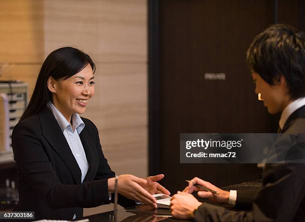 asian concierge in hotel with customer - asian receptionist stock pictures, royalty-free photos & images