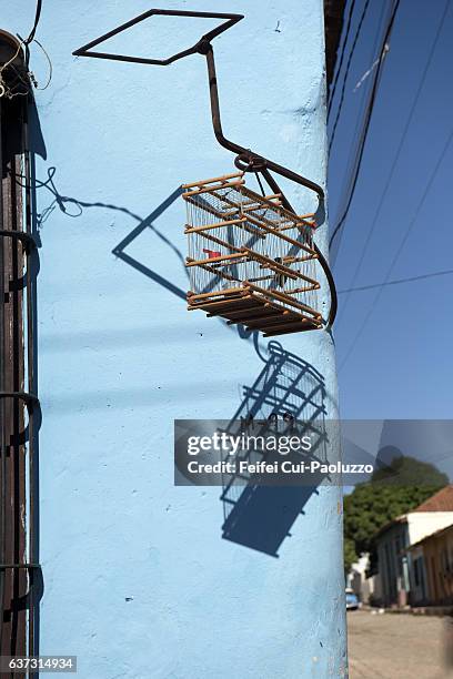 a bird cage hanging in front of a house at trinidad of cuba - cuba sancti spíritus stock pictures, royalty-free photos & images