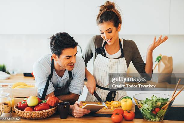 junges paar kochen in der küche - fragen beim kochen stock-fotos und bilder