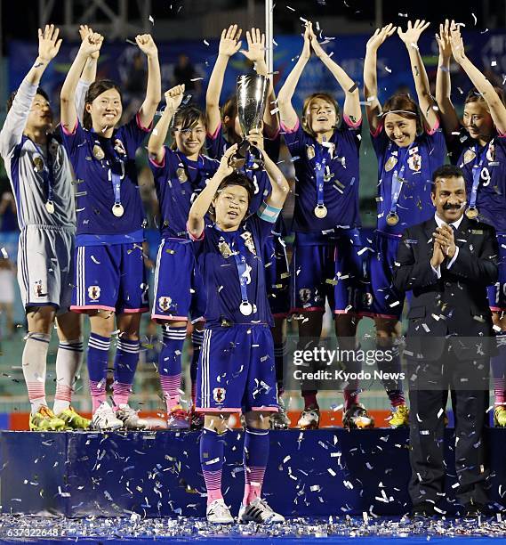 Vietnam - Captain Aya Miyama holds the trophy as Japan players celebrate in the award ceremony after winning their first Women's Asian Cup, beating...