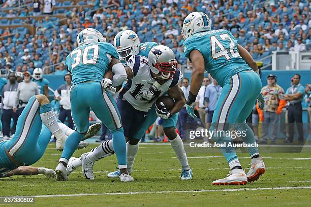 Michael Floyd of the New England Patriots breaks past Bacarri Rambo, Tony Lippett, and Spencer Paysinger of the Miami Dolphins to score a first...