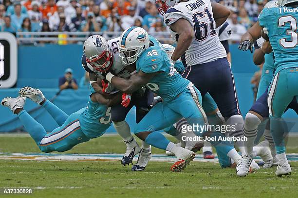 Neville Hewitt of the Miami Dolphins tackles Dion Lewis of the New England Patriots on January 1, 2017 at Hard Rock Stadium in Miami Gardens,...