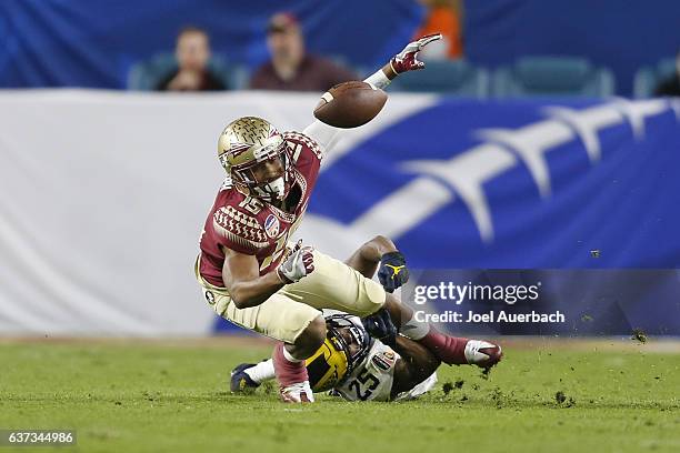 Dymonte Thomas of the Michigan Wolverines defends against Travis Rudolph of the Florida State Seminoles during the 2016 Capital One Orange Bowl at...