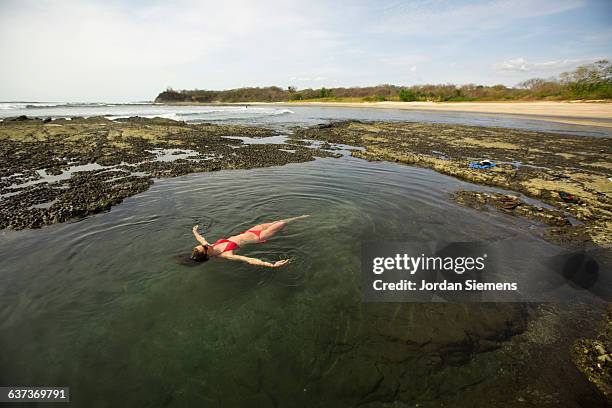 a woman relaxing in a natural pool. - nosara costa rica stock pictures, royalty-free photos & images