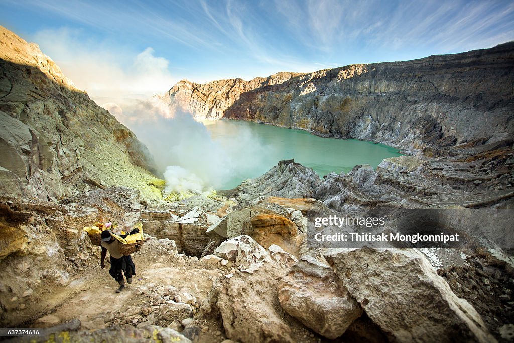 Miners are carrying sulfur from Ijen Volcano Blue flames