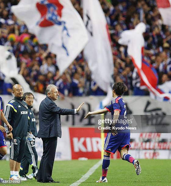 Japan - Atsuto Uchida touches the hand of Japan national men's soccer team coach Alberto Zaccheroni after scoring a goal during the first half of an...