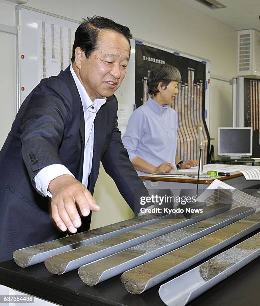 Japan - Makoto Okamura , a professor at Kochi University, displays deposited substances collected from a pond in Kochi Prefecture's Tosa, on May 26...